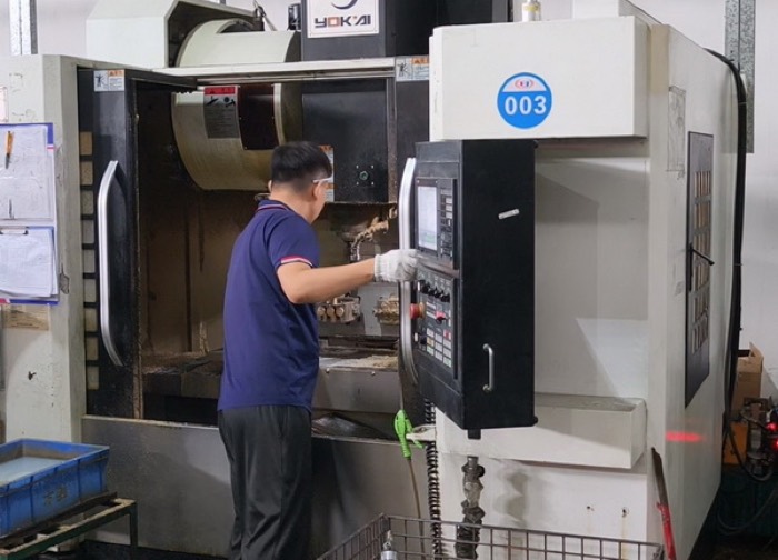 Operator running a precision CNC machining centre